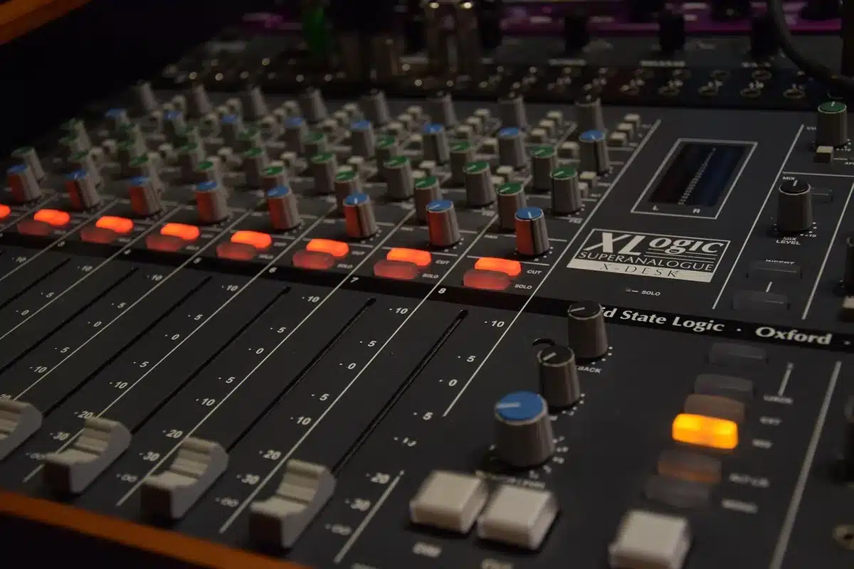 Due figure silhouette in studio con synth e consolle, atmosfera decisa