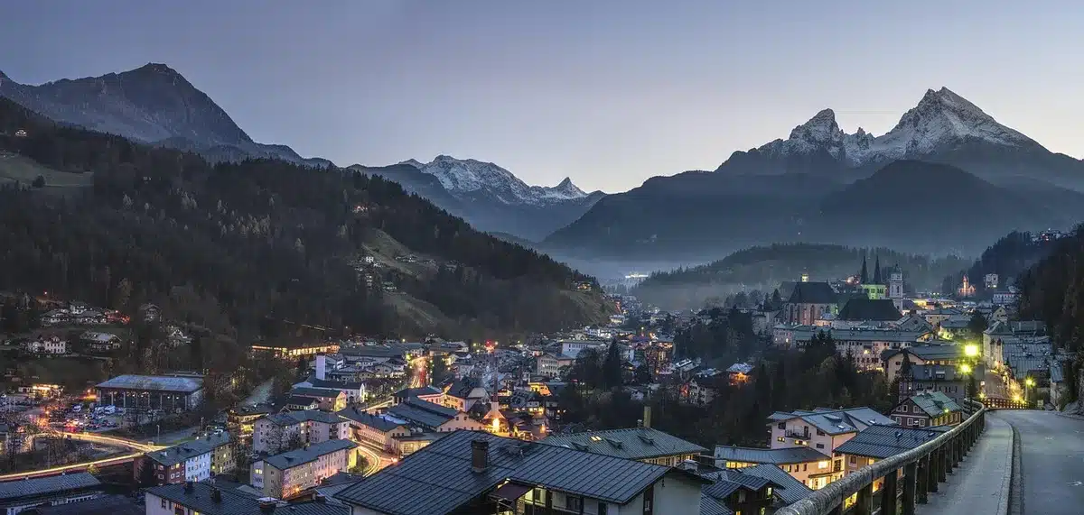 Paesaggio urbano iper-reale con architetture futuristiche e montagne sullo sfondo