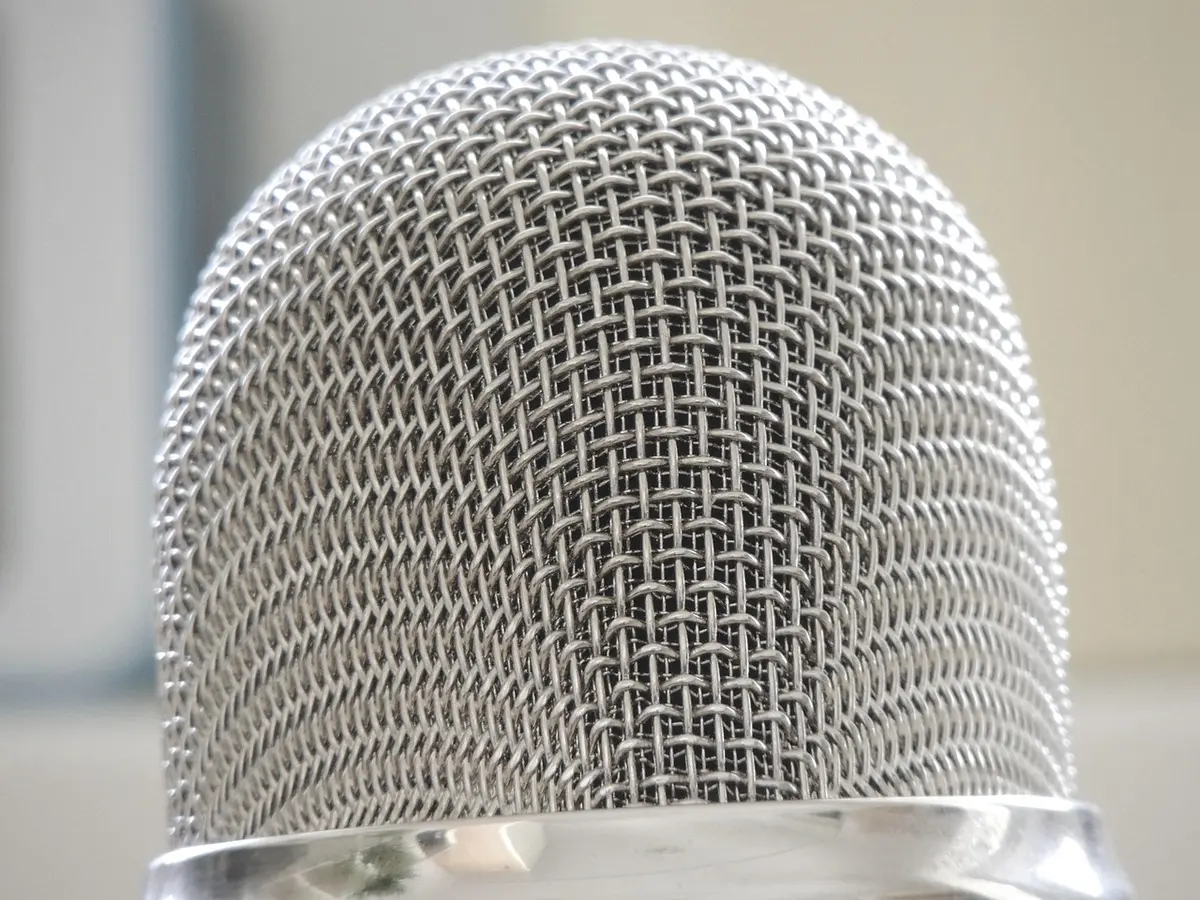 Microfono in studio con luci calde che suggerisce un'atmosfera intima di registrazione