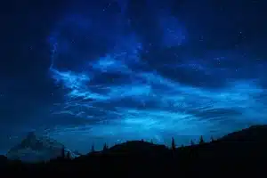 Silhouette di persone attorno a un tavolo con luci soffuse, atmosfera di tensione