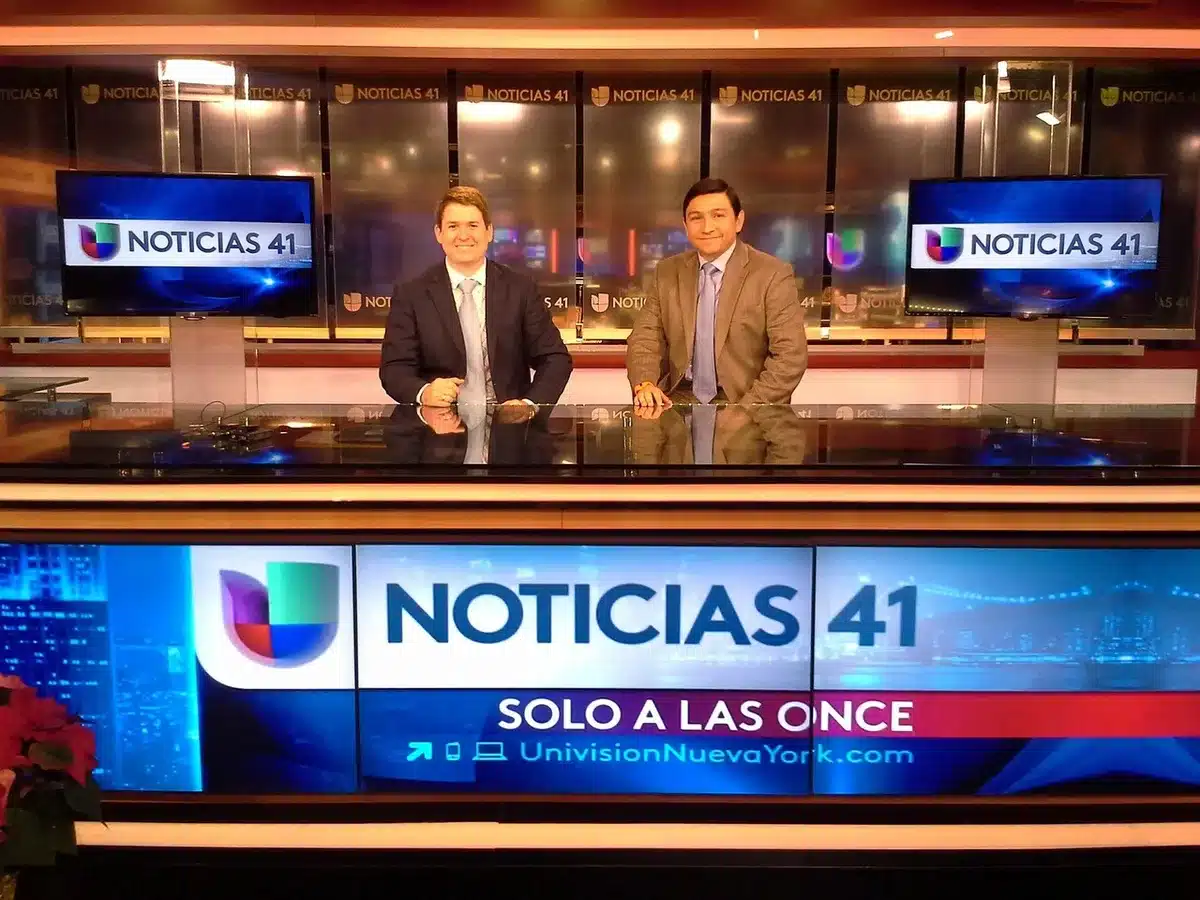 Studio televisivo con due figure distanti durante un acceso confronto