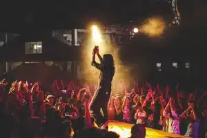 Pubblico che applaude una band in controluce sul palco