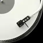 Giradischi e sintoamplificatore compatto su una mensola hi-fi, dettaglio tonearm e unità amp