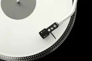 Giradischi e sintoamplificatore compatto su una mensola hi-fi, dettaglio tonearm e unità amp