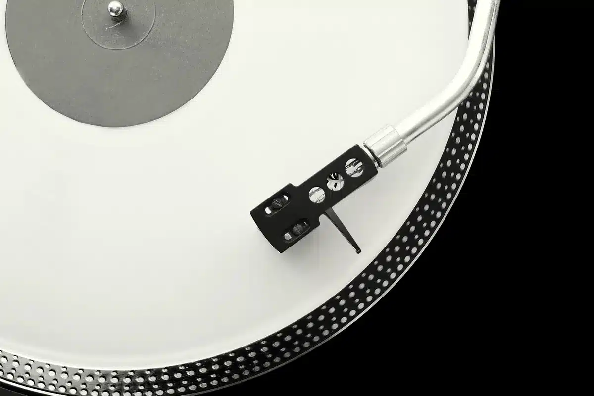 Giradischi e sintoamplificatore compatto su una mensola hi-fi, dettaglio tonearm e unità amp