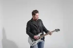 Scrivania con schizzi punk, matite e chitarra in uno studio domestico