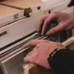 Vinile 180 g parzialmente estratto dalla sua copertina, mani che lo maneggiano su un tavolo